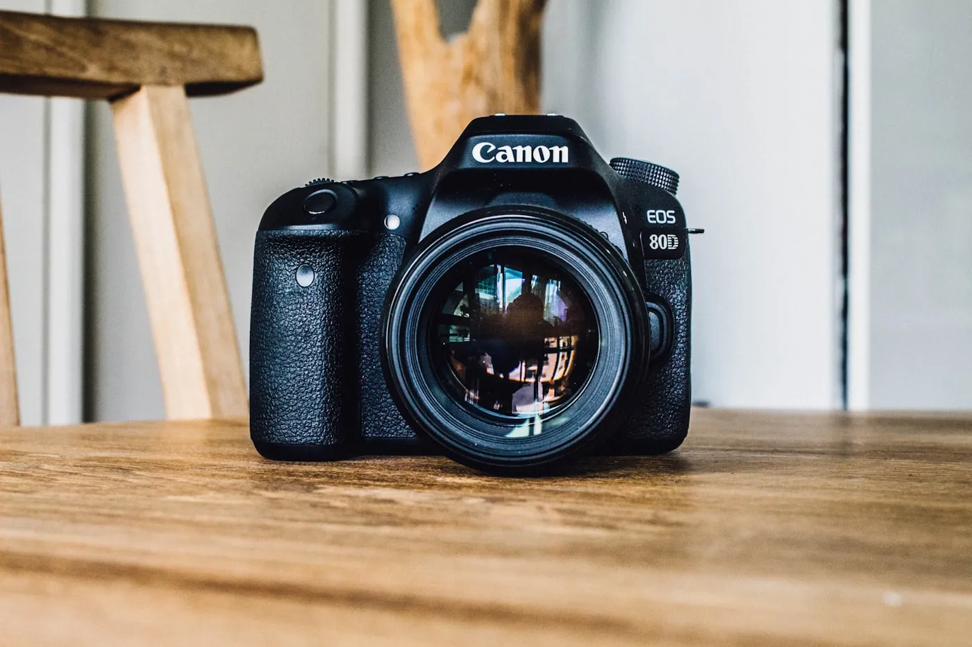 Fotocamera reflex Canon appoggiata su un tavolo di legno
