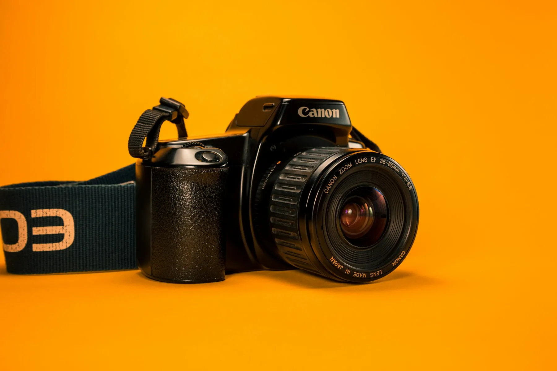 Fotocamera reflex su fondo arancione acceso